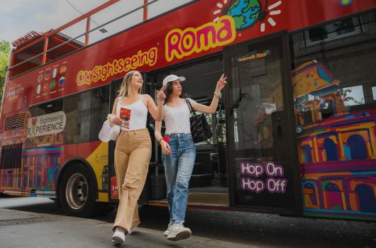 Due donne scendono da un autobus turistico a Roma.